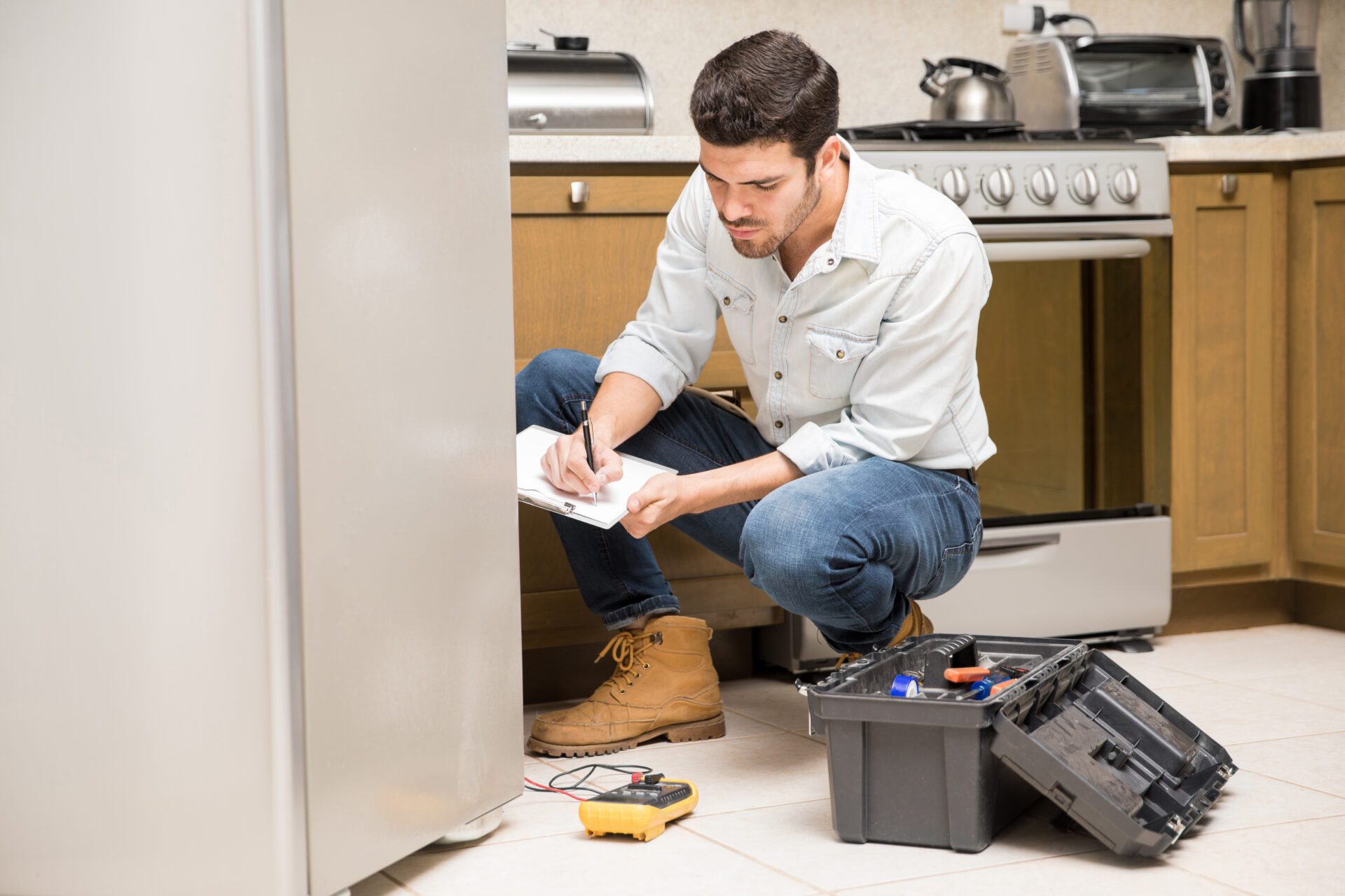 A professional plumber utilizing electronic leak detection equipment on a residential floor.
